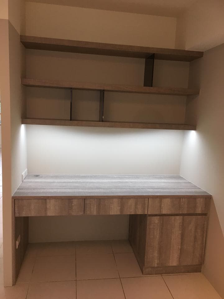 這張照片是一張木製書桌,有三個抽屜和一個櫃子,書桌上方有一個木架,書架上有三層隔板。