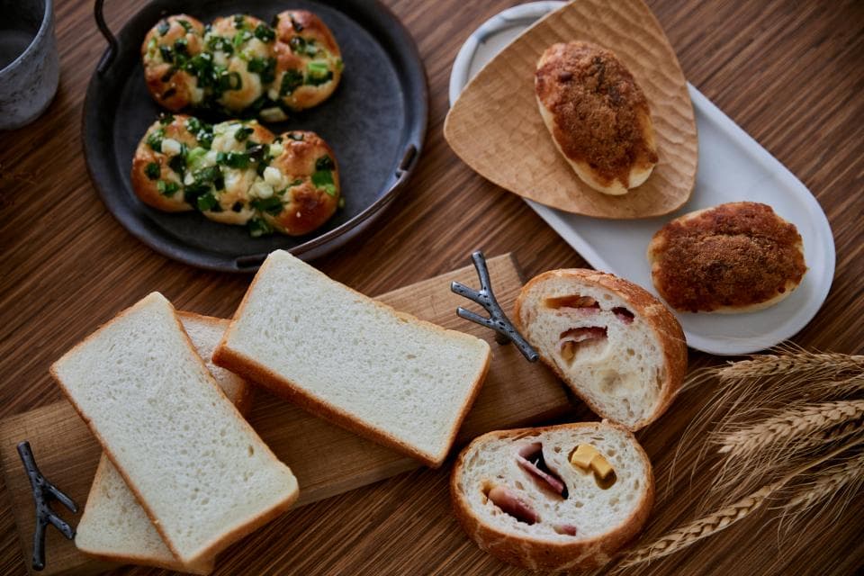 這張照片是幾片吐司和一些麵包。 吐司看起來很蓬鬆,麵包上面有肉和起司,看起來很美味。