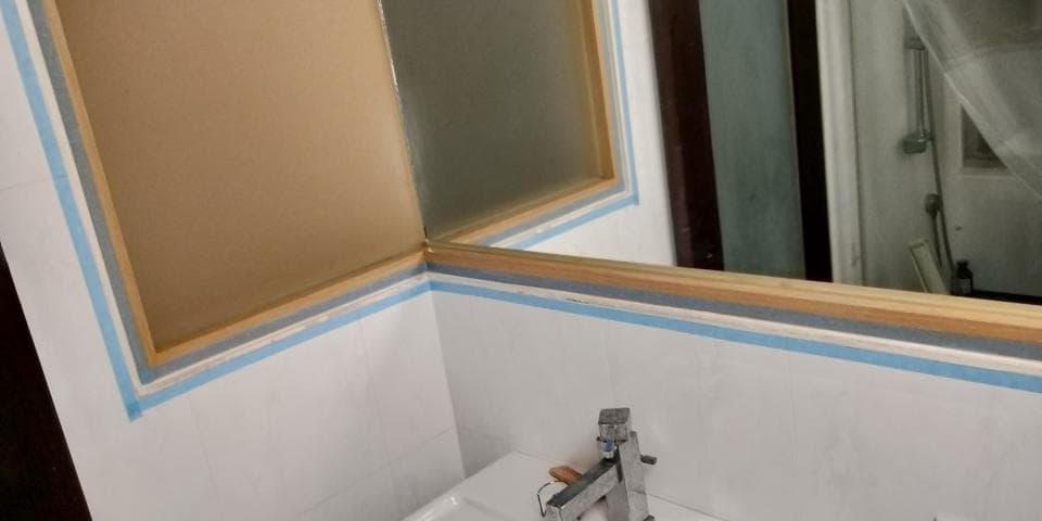 這張照片是一面浴室的鏡子,周圍用多層的膠帶裝飾,呈現出乾淨整潔的視覺效果。