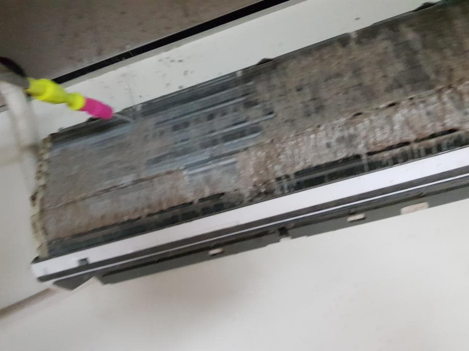 1) 照片顯示一個被噴灑水並正在清潔的空調濾網