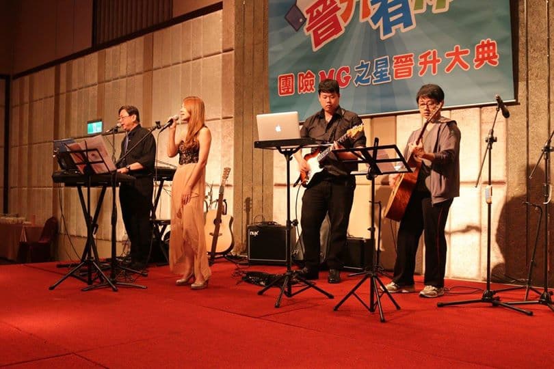 這張照片是四位音樂家在舞臺上演奏。他們都穿著正式的服裝,正在演奏各自的樂器。這是一個充滿活力和歡樂的現場音樂表演。