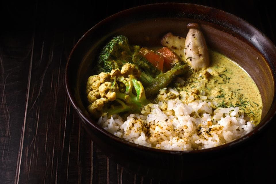 這張「綠咖哩雞」的照片是一碗以椰奶為基底的綠咖哩,上面放著雞肉、花椰菜、青椒、香菜和米飯。