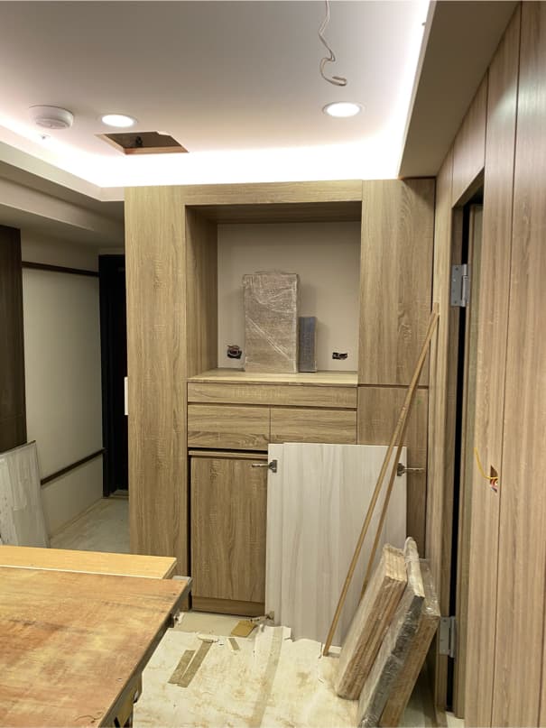 1) 照片顯示一個木製的房間,房間內有一個木頭製成的櫥櫃,櫥櫃上方的隔層放著一些物件