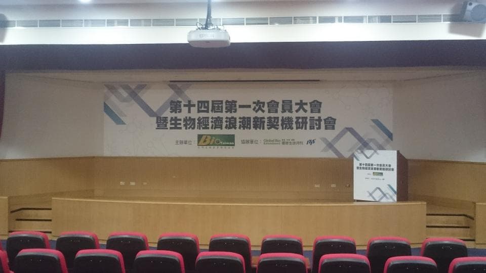 1) 照片顯示一個會議室,前方有一個舞台,舞台上掛著「第十四屆國際一次會會員大會暨生物機體溝通訊號學術研討會」的標語