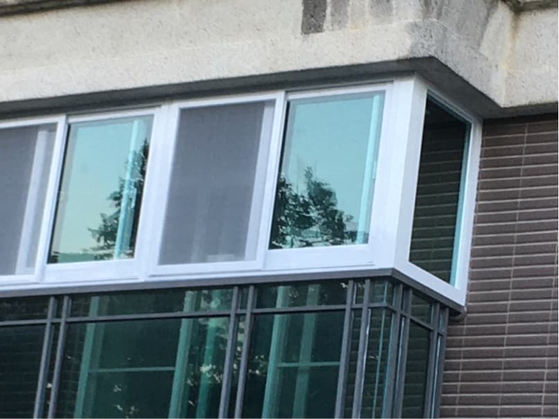 這張「窗戶」的照片是一個有鐵窗的落地窗,窗戶是由白色鋁框組成,窗戶外側有遮陽網,窗戶內側有鐵窗。