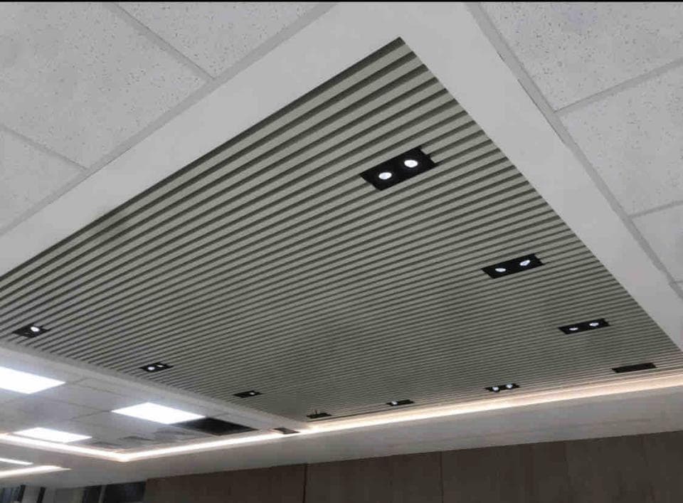 這張照片是一間房間的天花板,上面裝有許多燈具,並以白色的框架與灰色條紋裝飾,呈現出時尚且現代的風格。