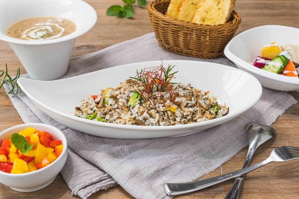 這張「餐桌」的照片是一道美味的炒飯,旁邊放著一些水果和麵包。