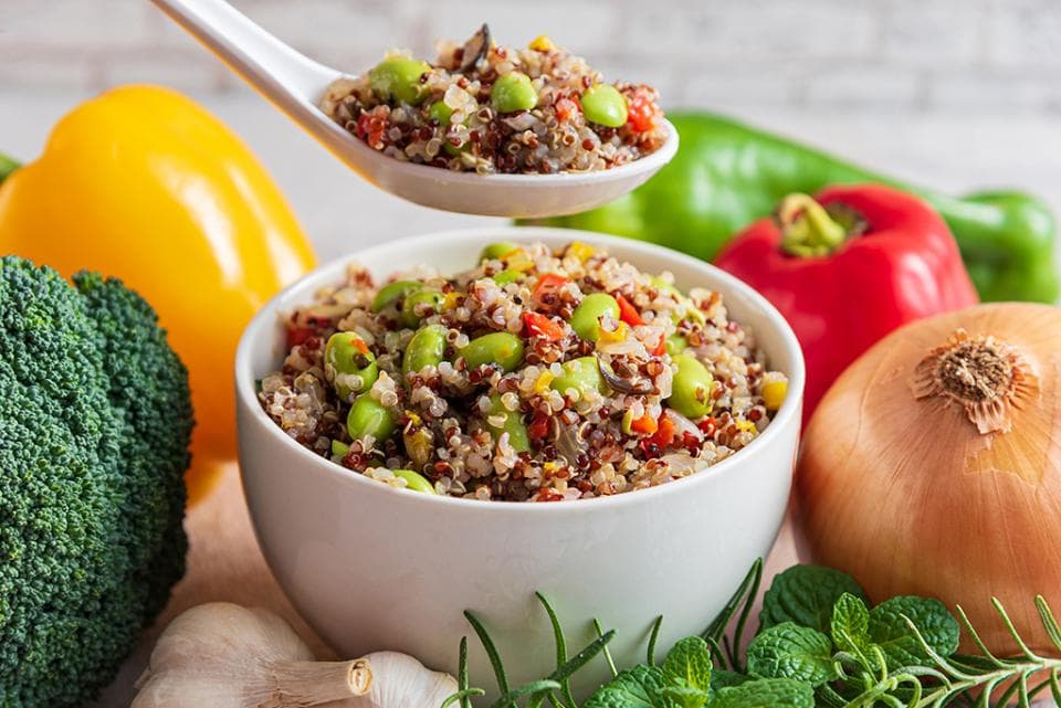 這張照片是一碗裝滿五顏六色的藜麥沙拉,看起來非常美味。沙拉裡有紅色的紅椒、黃色的玉米、綠色的毛豆和一些香草,而且每一種食材看起來都非常新鮮。