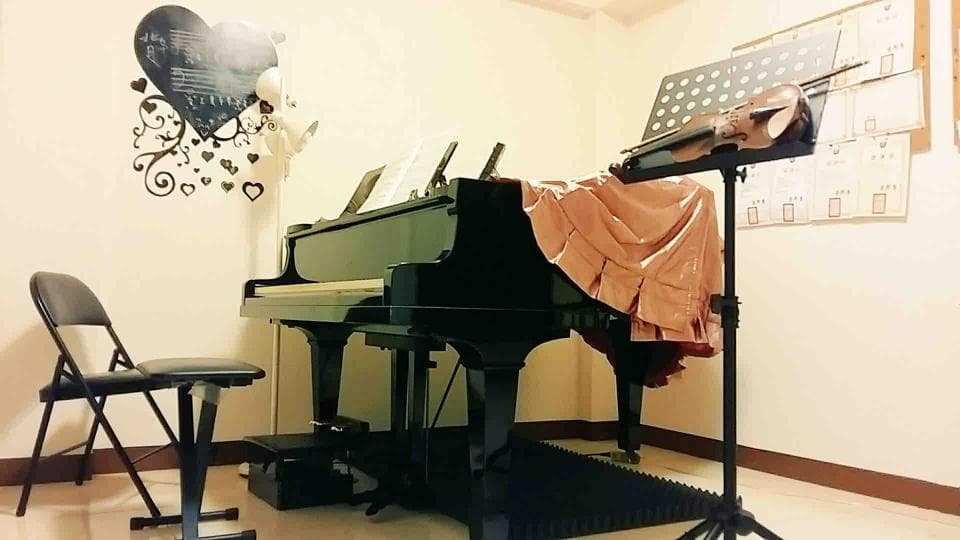 1) 一張黑色鋼琴,配有黑色琴凳和音樂架,架上放著小提琴