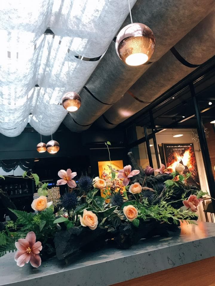 1) 照片顯示一個裝飾著花朵的木質吧台,上面有一排吊燈