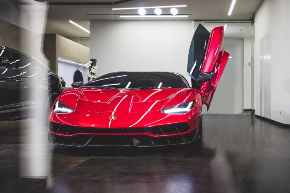 這張「一輛紅色跑車」的照片是一輛停在室內車庫的紅色蘭博基尼,車門打開,展現出車內設計。