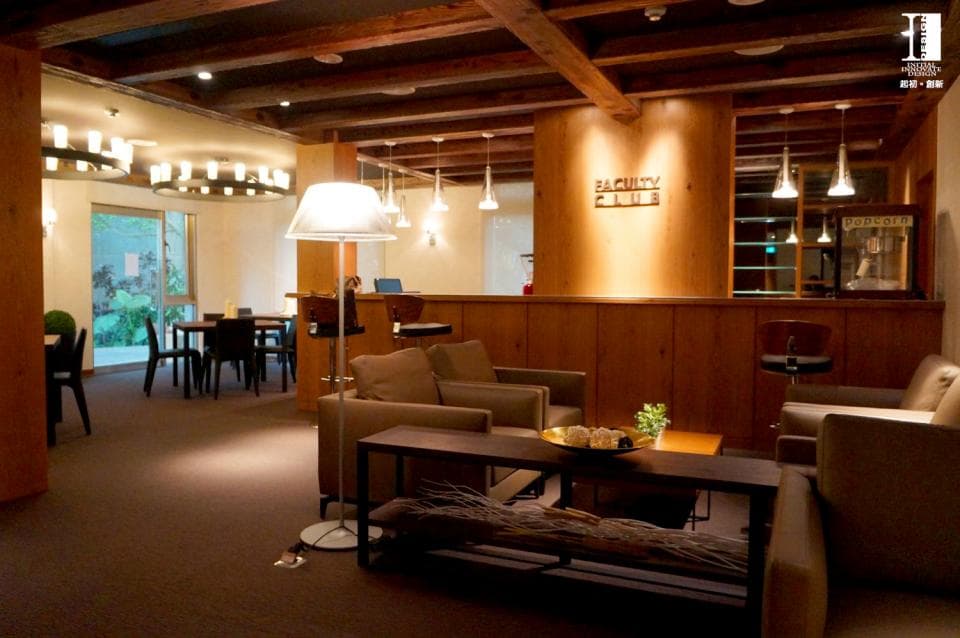 這張照片是一個現代化的休息區,裡面有木質傢俱和舒適的沙發,以及木製的牆壁和天花板。最顯眼的是牆上寫著 Backyard Cafe 的字樣,讓這個空間充滿了時尚休閒的氛圍。