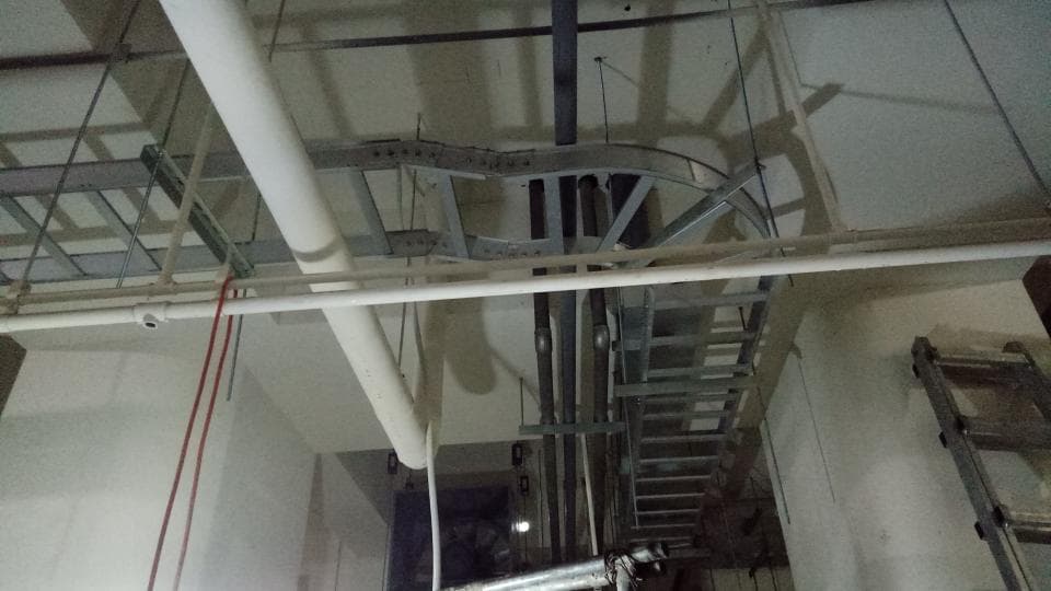 1) 照片顯示一個建築物的天花板,上面有管道和電線