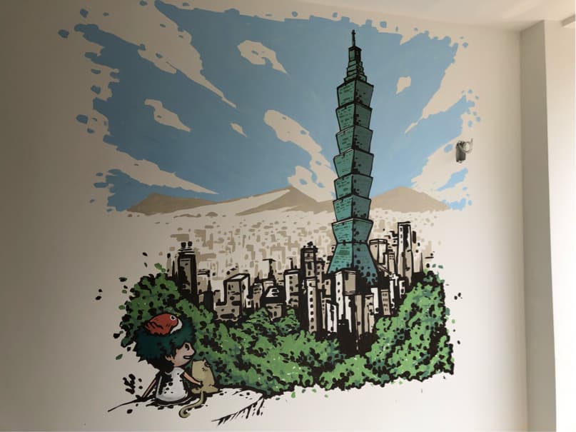 這張「臺北101大樓」的照片是一幅牆壁上的壁畫,畫著臺北101大樓,以及周圍的建築和綠樹。