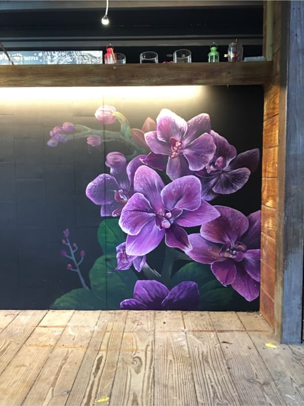 這張「牆壁上畫著紫色蘭花」的照片是一幅美麗的藝術品,蘭花栩栩如生。