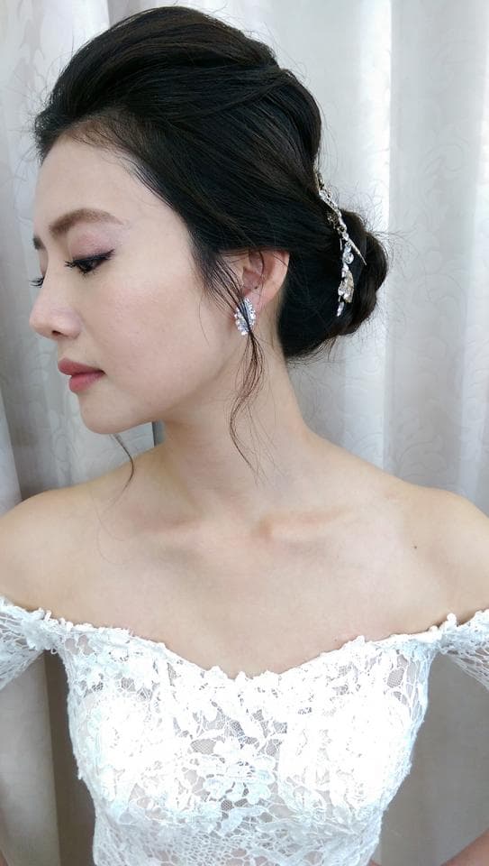 這張「新娘」的照片是一個穿著白色蕾絲婚紗的女性,她戴著精緻的耳環和頭飾,看起來優雅美麗。