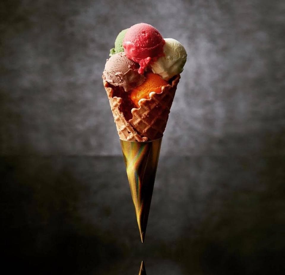 這張「冰淇淋」的照片是一隻裝著四種口味冰淇淋的蛋筒,冰淇淋的顏色分別是綠色、紅色、白色和橘色。