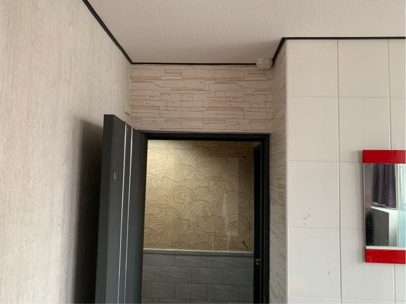 1) 這張照片顯示了一個房間的內部,房間裡有一扇黑色的門,門的後面是一個空間,可以是浴室或另一個房間