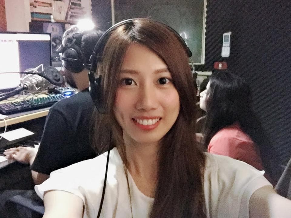 這張「錄音室」的照片是一個女生戴著耳機在錄音,背景有另外一個人,旁邊有電腦和麥克風。