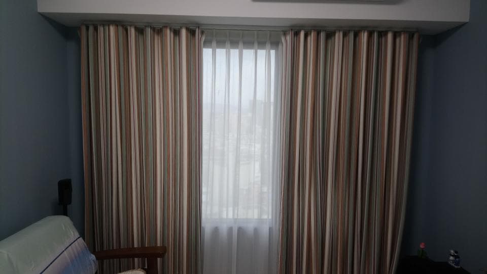 1) 照片顯示一個房間的窗戶,窗戶上有條紋窗簾和薄紗窗簾