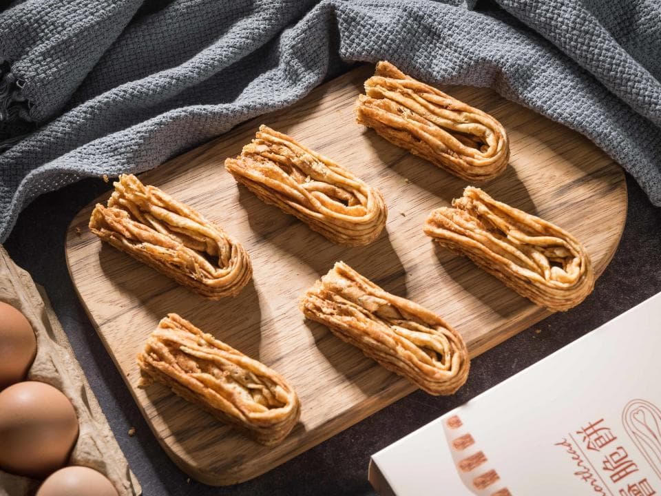 這張「雞蛋酥」的照片是六個酥脆的雞蛋酥放在木板上的照片。