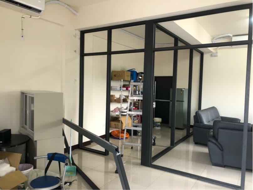 這張照片是一個辦公室,最重要的是房間中央的黑色辦公椅。黑色的椅子是皮革的,看起來非常舒服,且周圍有黑色的玻璃窗,暗示著這個辦公室的現代感。