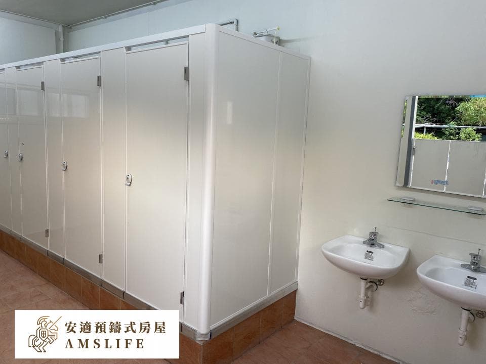 這張照片是一個公共廁所,最重要的是牆上的一排白色隔間,像是獨立的小房間,供人使用。