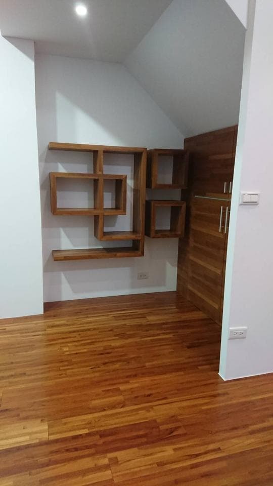 這張照片是 一個現代化的木地板房間,房間裡有一個木製的壁架和一個木門。