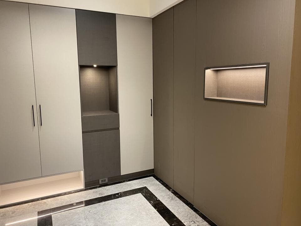 這張照片是一個裝潢精緻的現代化玄關,牆壁上有一個內嵌式照明燈,看起來十分美觀。