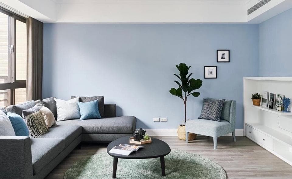 這張照片是現代化的客廳,沙發是房間的主要焦點。它被安排在窗戶前,並配有舒適的抱枕和靠墊,看起來十分舒適。