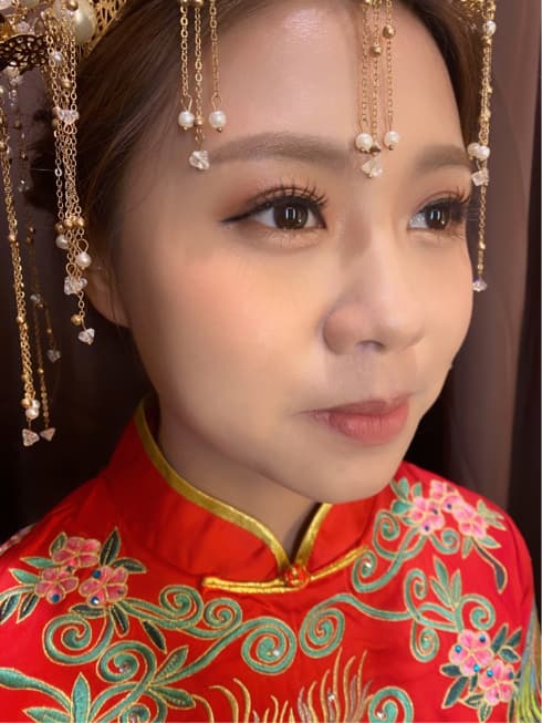 這張照片是一個穿著紅色旗袍的女子,她戴著精緻的頭飾,顯得優雅美麗。