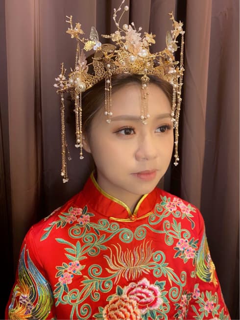 這張「新娘」的照片是一個穿著紅色旗袍的女性,頭上戴著金色的頭飾,看起來很漂亮。