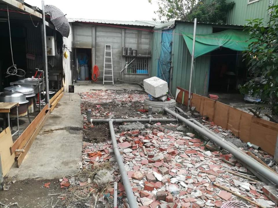 這是一張在戶外拍攝的照片,照片中有一個混凝土建築物,地上散落著碎石和瓦礫