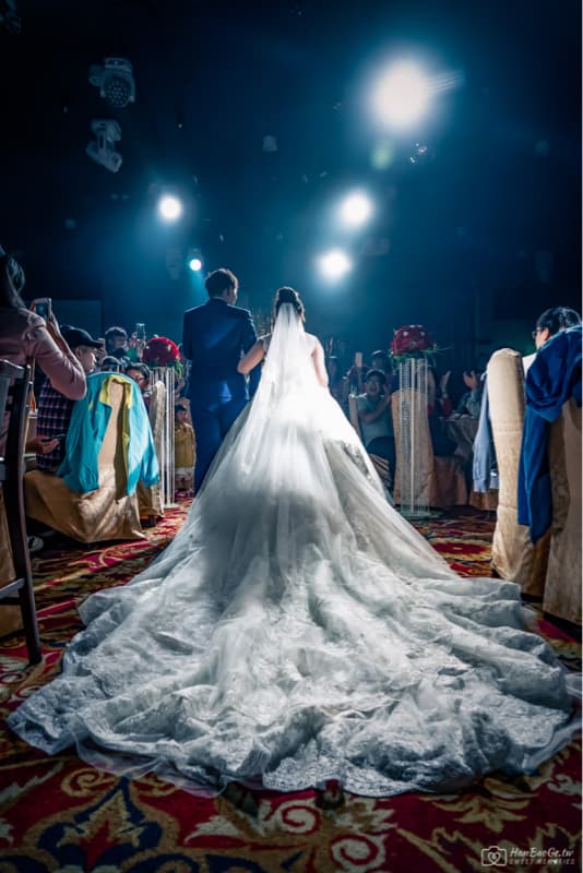 這張「婚禮」的照片是一對新人正在走紅毯,新娘穿著一件白色蕾絲婚紗,新郎則穿著西裝。