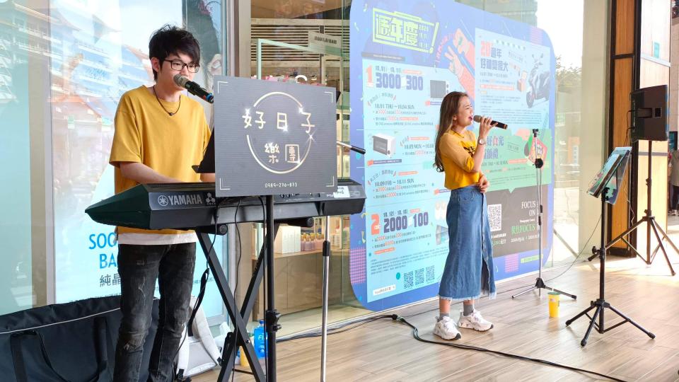 這張照片是一對年輕人正在街頭表演,他們正在使用電子琴和麥克風演唱。