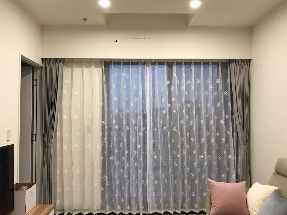 1) 照片描述: 這是一張室內的照片,窗戶上裝有灰色的窗簾和白色蕾絲窗簾,窗戶外是夜晚的街景