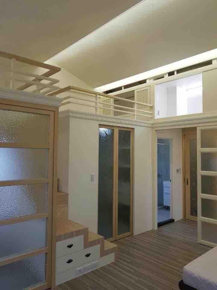 這張照片是一間裝潢精緻的現代化臥室,房間裡擺放著木製樓梯,下方設有抽屜,方便收納,空間設計時尚簡約。