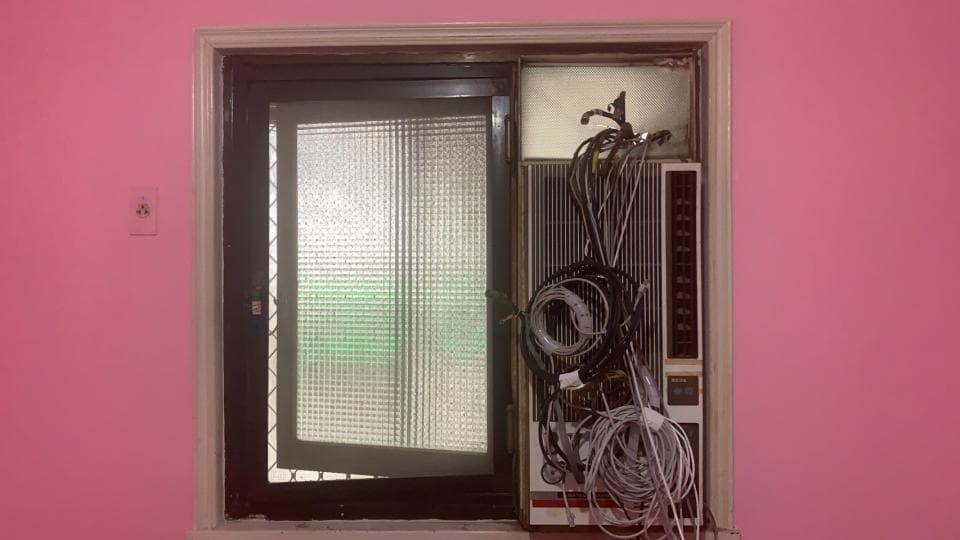 1) 照片顯示了一個裝有窗戶和空調的粉紅色牆壁