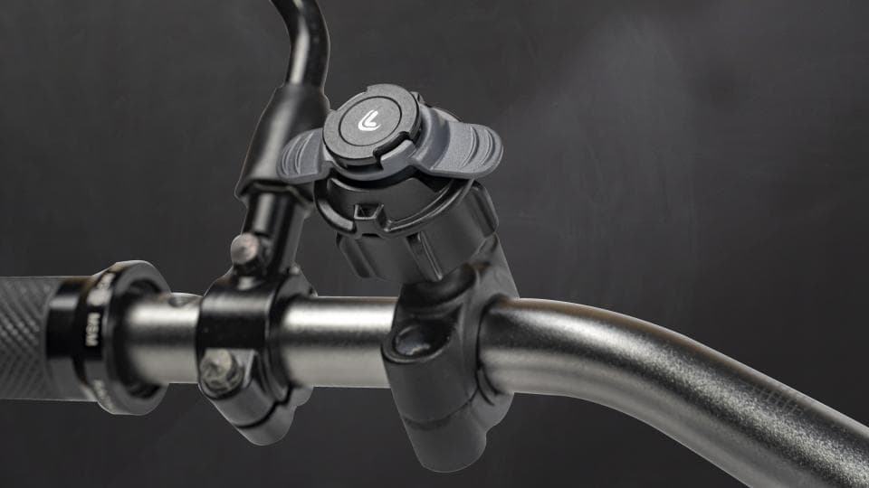 這張照片是一個摩托車的把手,最顯眼的是安裝在把手上的手機支架,支架呈黑色,有兩個旋鈕可以調整手機的放置位置。