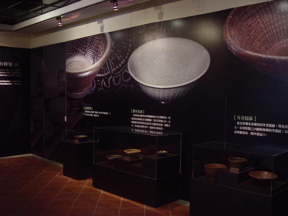 1) 照片顯示博物館展覽室,牆壁上懸掛著三個古董瓷器