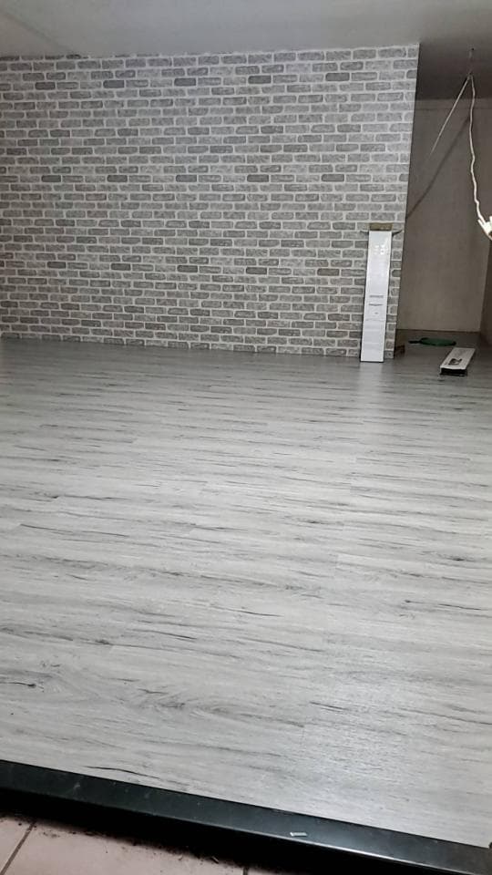 1) 照片顯示一個房間,房間裡有磚牆和木地板