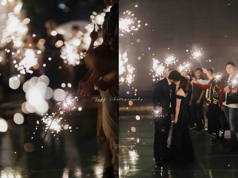 這張照片是一對情侶在人群中擁抱,周圍的人們正在揮舞著閃閃發光的煙火,營造出浪漫的氛圍。