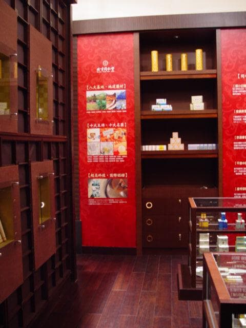 這張「商店」的照片是一個木製的房間,裡面放著很多商品展示架,牆壁上有紅色廣告牌,上面印有產品介紹。