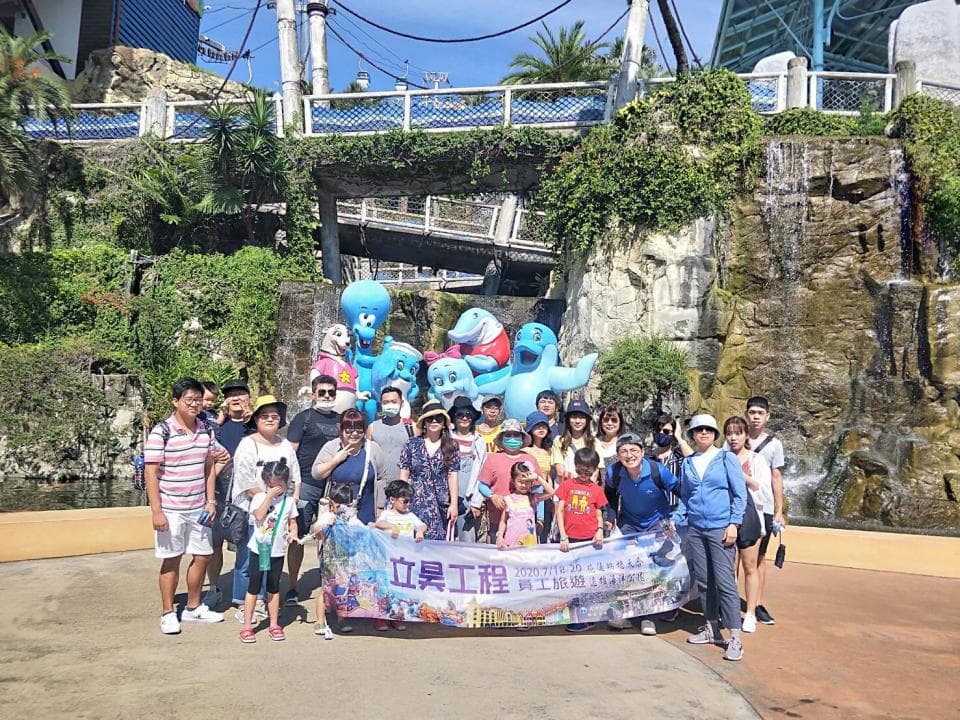 這張照片是一群人在一個遊樂場裡合影。照片中最重要的是他們手裡舉著的橫幅,上面寫著「屏東工程」,並且有「屏東工程」的logo。