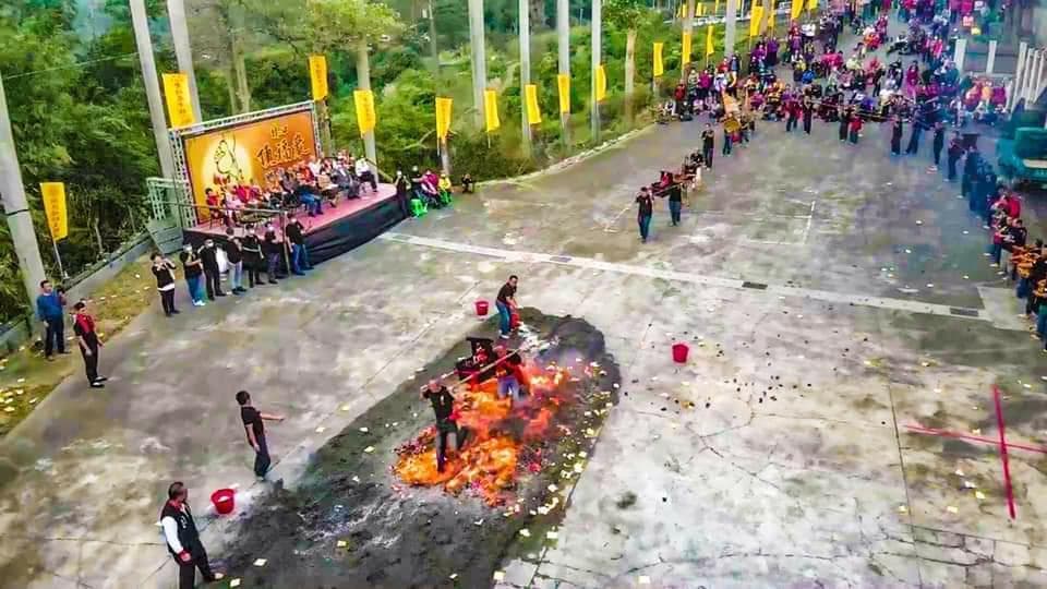 這張「火祭」的照片是,一群人在空地上圍繞著一個燃燒的火堆。