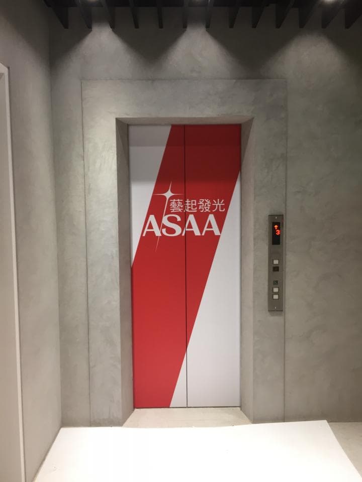 這張電梯的照片是,電梯門上印著「華麗登場」和「ASAA」的標誌。