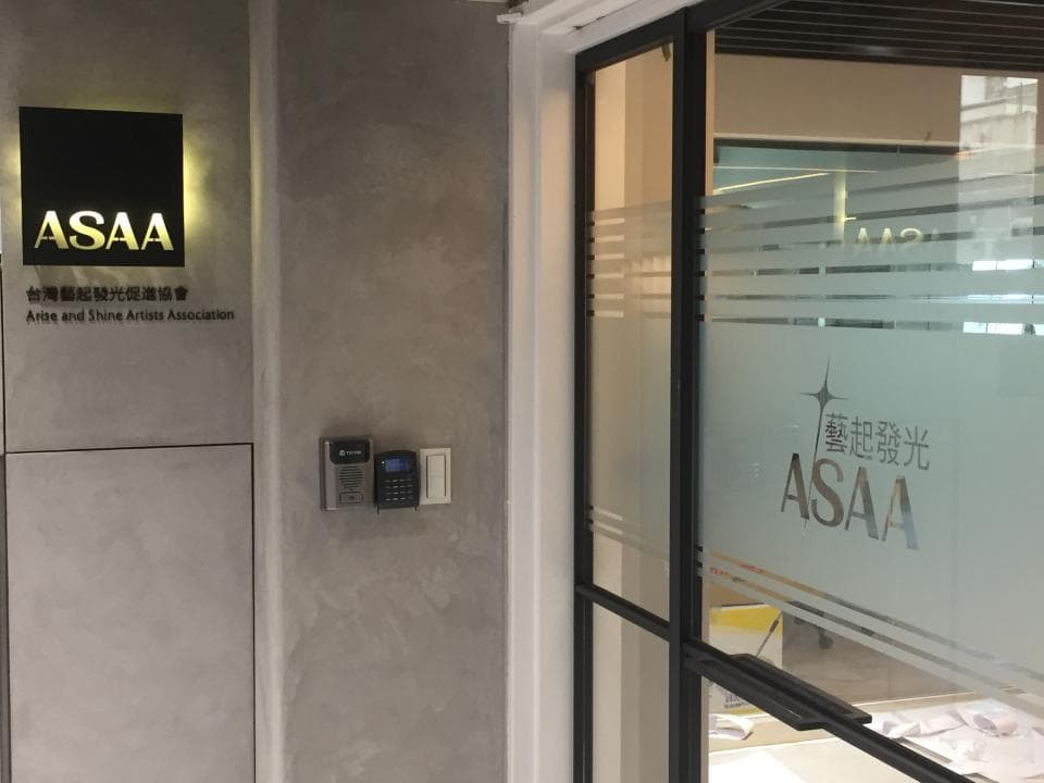 這張「藝術與閃光藝術家協會」的照片是一間辦公室的入口,門上貼著協會的標誌。牆上有一個門禁系統,看起來很安全。