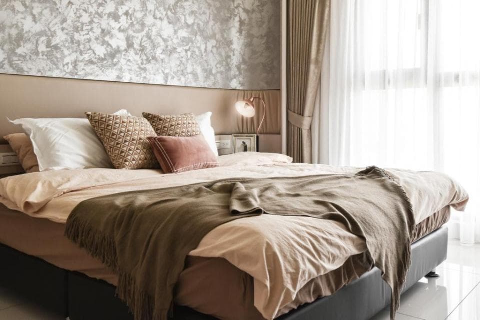 這張「臥室」的照片是一個舒適的床,床頭板上有兩個枕頭和一個毛毯,床邊有一個床頭櫃,窗戶邊有窗簾。