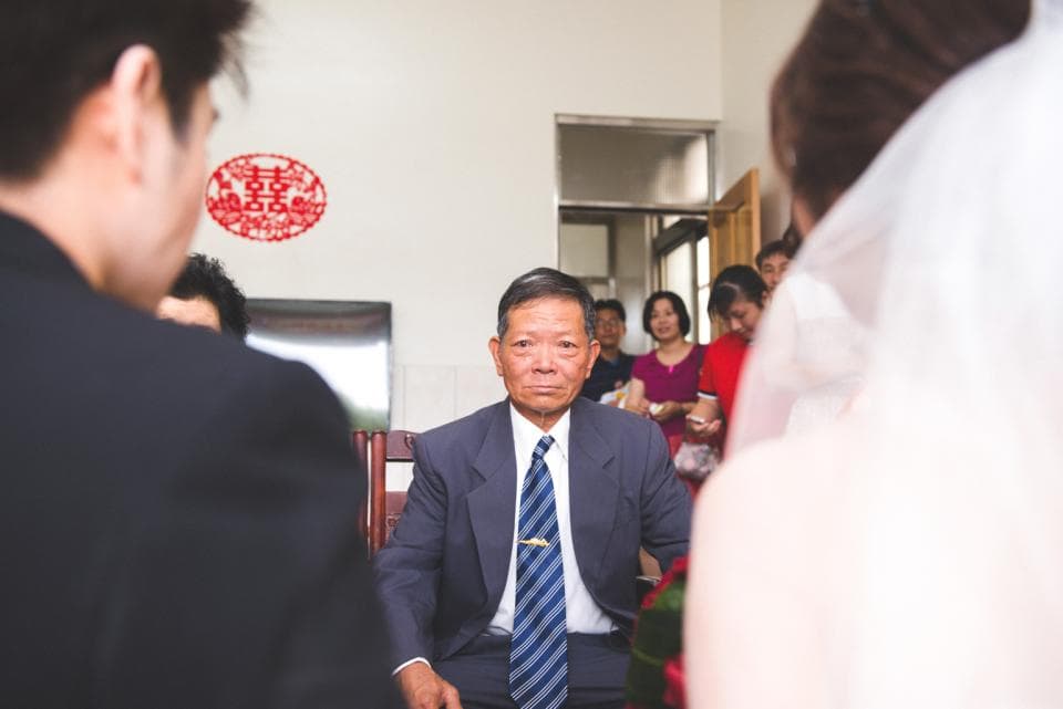 這張照片是一個婚禮,照片裡有一位身穿西裝的男士正準備迎接新娘。他看起來很緊張,他的表情很嚴肅,似乎在等待著什麼。