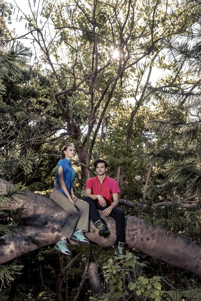 這張照片是一個年輕夫婦坐在樹枝上的畫面,他們看起來很放鬆,享受著大自然的風景。